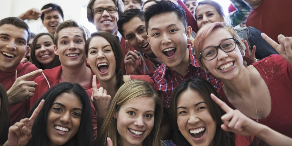 Portrait of large group of students cheering at college sporting event